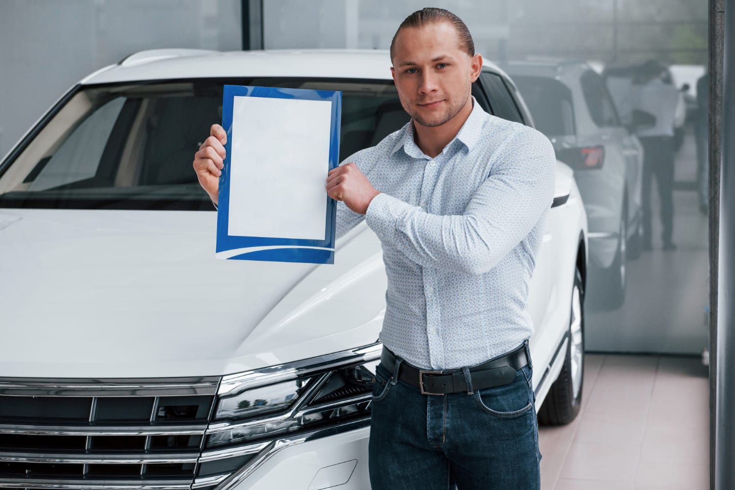 important-document-manager-stands-in-front-of-modern-white-car-with-paper-in-hands (1)