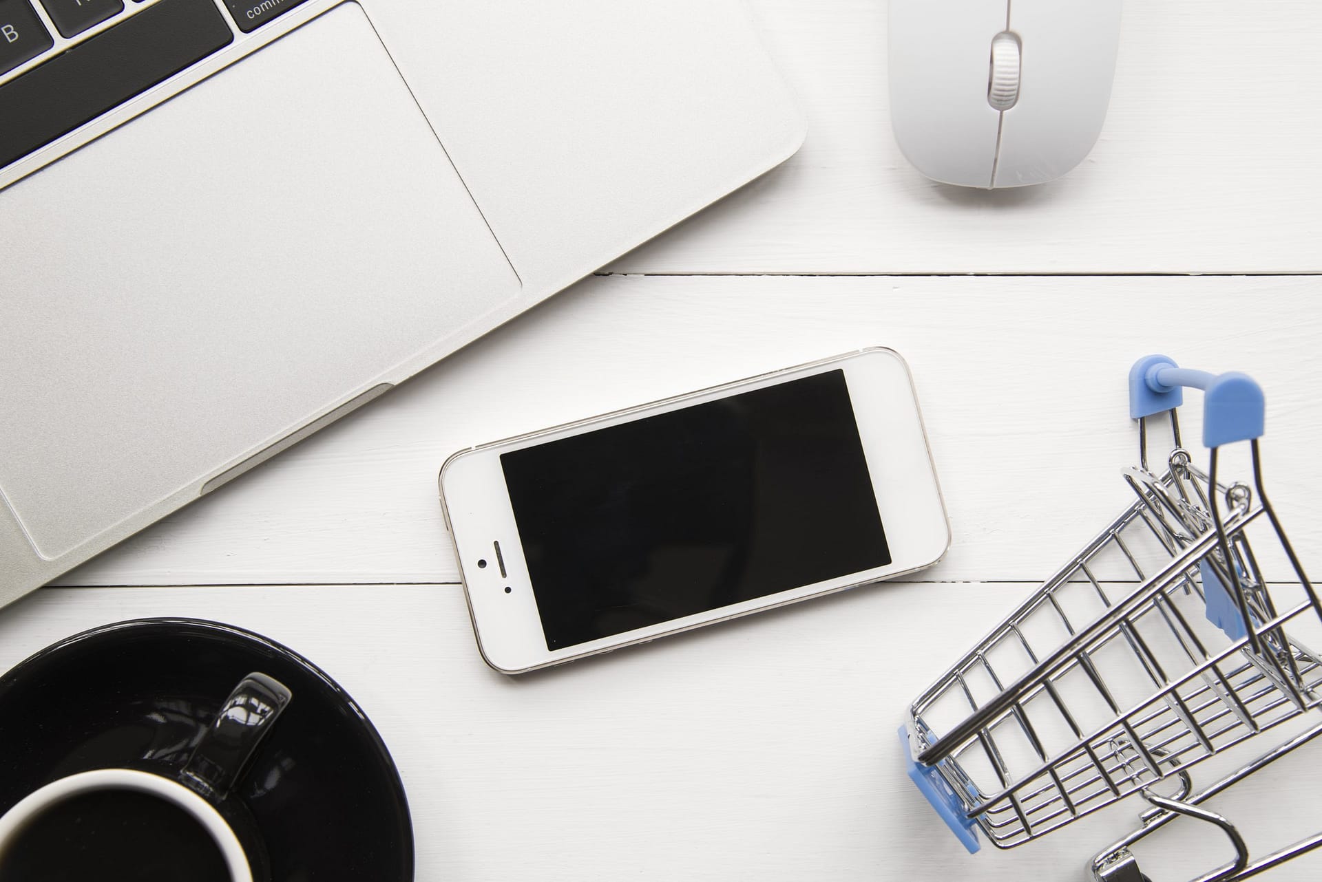 smartphone-near-laptop-and-shopping-trolley